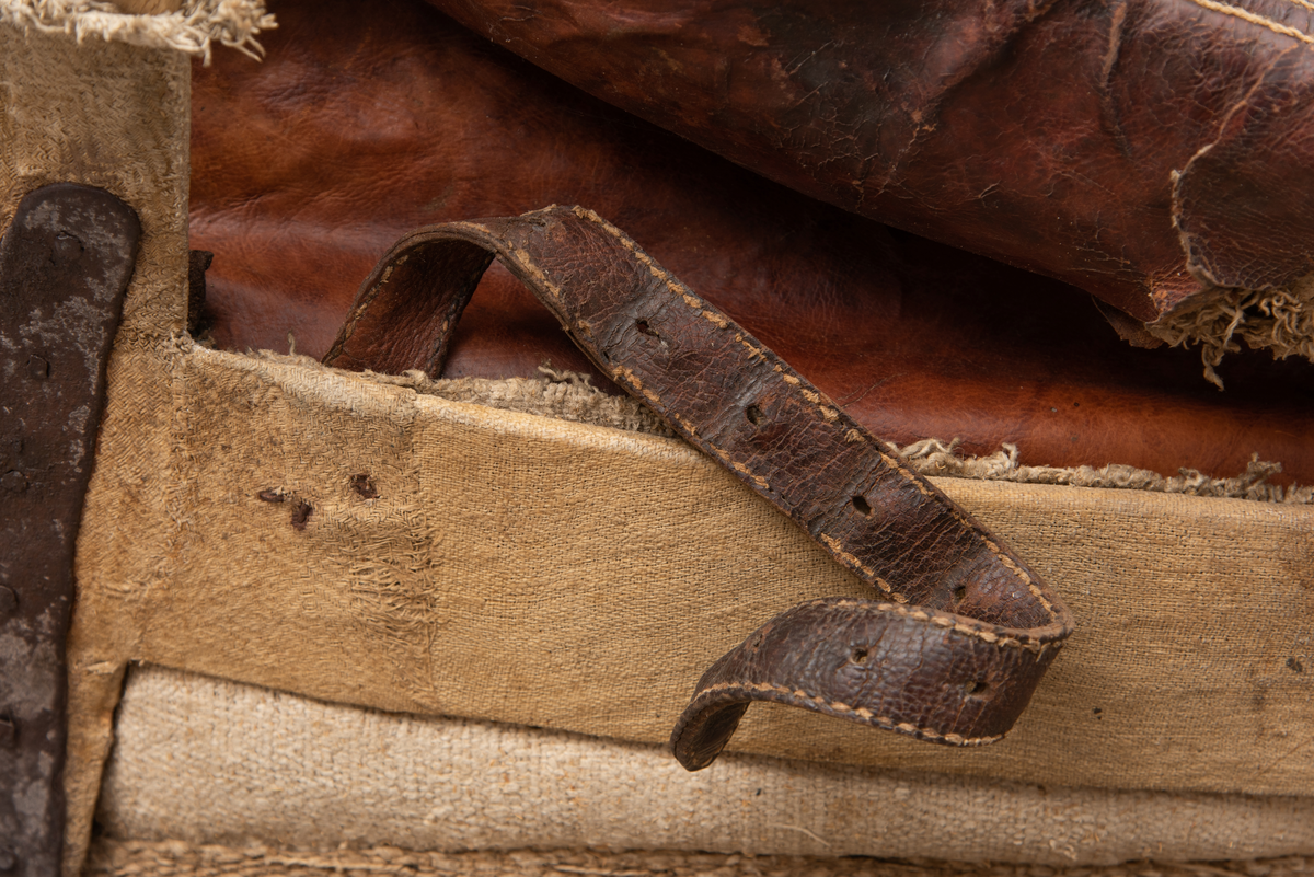 Håndlaget sal fra 1787. Bygd opp utifra en treform med lerret (strie). Pånaglet lær på sidene av stolen og på baksiden og yttersidene av selve stolen. Læret på den ene yttersiden av stolen er preget med inskripsjonen "1787 M.E.D.B." Stolen er innvendig fylt med stopp og trukket med grønt ullstoff som er påbrodert kruseduller. Læret er preget med en forenklet akantusranke. Salputen under er sydd i lerret (strie) og fylt med stopp, og festet kun på den ene siden. Alle remmene er i lær, nagler og spenner av jern.