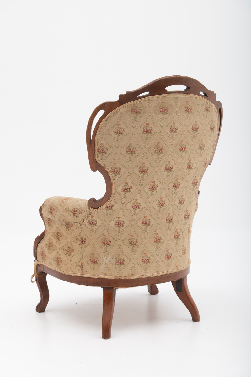 Gruppe med sofa, to lenestoler og tre mindre stoler uten armlener i stilen nyrokokko. Gyllengult trekk med rosemotiv og mørkt treverk med buede, organiske linjer.
