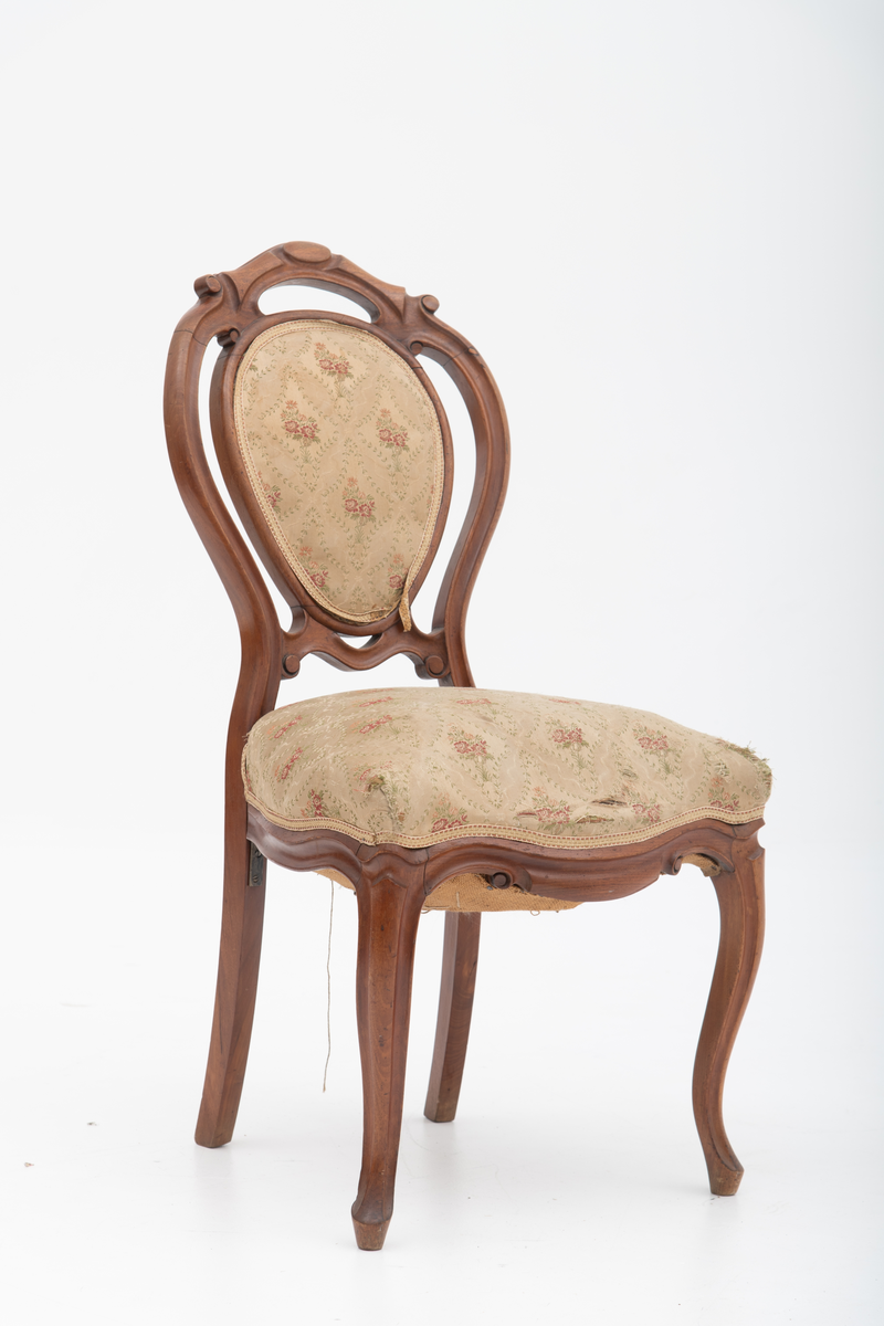 Gruppe med sofa, to lenestoler og tre mindre stoler uten armlener i stilen nyrokokko. Gyllengult trekk med rosemotiv og mørkt treverk med buede, organiske linjer.
