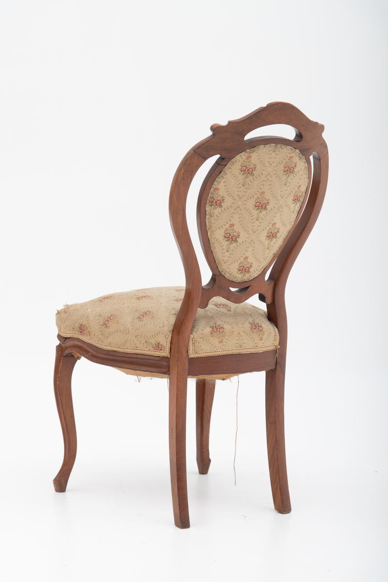 Gruppe med sofa, to lenestoler og tre mindre stoler uten armlener i stilen nyrokokko. Gyllengult trekk med rosemotiv og mørkt treverk med buede, organiske linjer.

