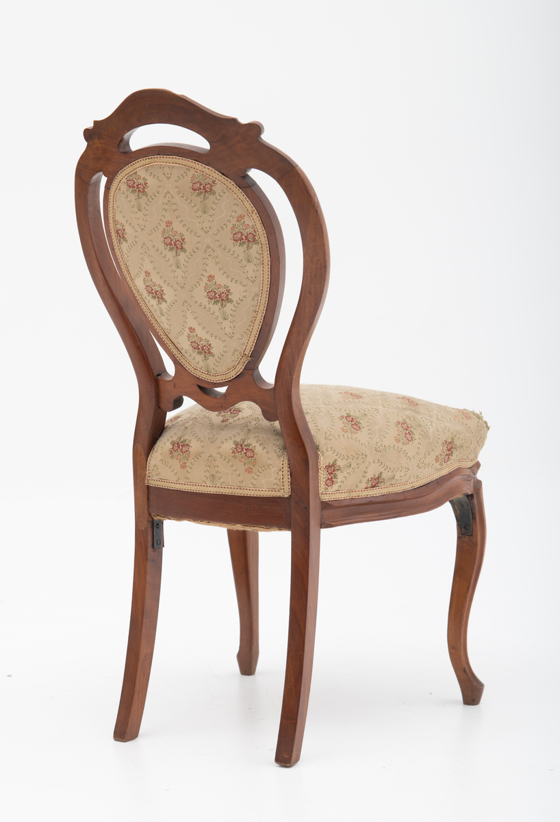 Gruppe med sofa, to lenestoler og tre mindre stoler uten armlener i stilen nyrokokko. Gyllengult trekk med rosemotiv og mørkt treverk med buede, organiske linjer.
