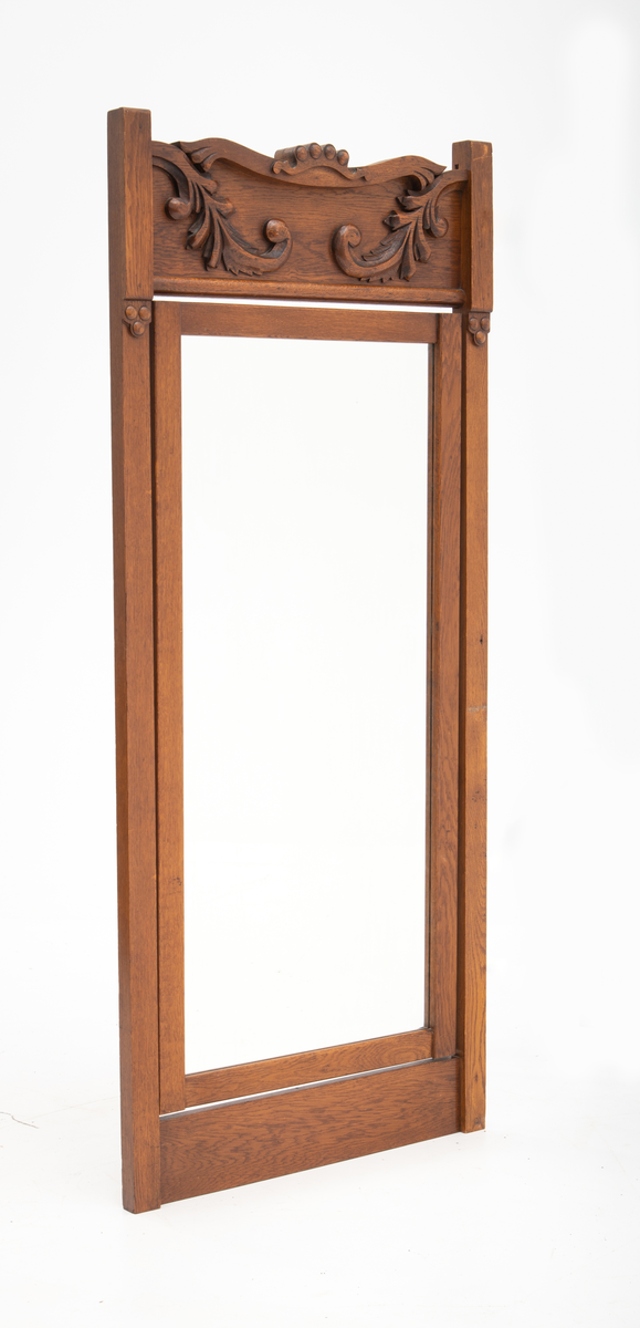 Speil tilhørende entremøbel. Rektangulært vippespeil montert i ramme med utskjæringer.. Slipt speilglass.