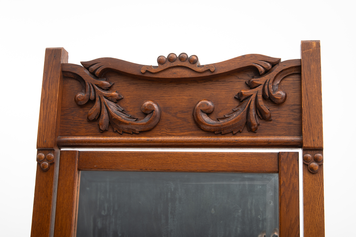 Speil tilhørende entremøbel. Rektangulært vippespeil montert i ramme med utskjæringer.. Slipt speilglass.