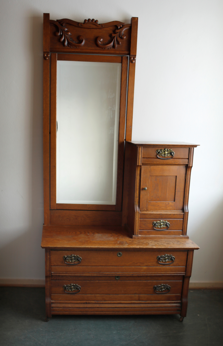 Speil tilhørende entremøbel. Rektangulært vippespeil montert i ramme med utskjæringer.. Slipt speilglass.