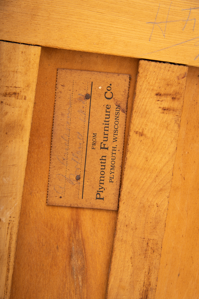 Kommode. Topplate og fronten på kommoden er bølget i formen. To mindre skuffer øverst, og en stor låsbar skuff nederst. Treknotter. Ben med hjul.