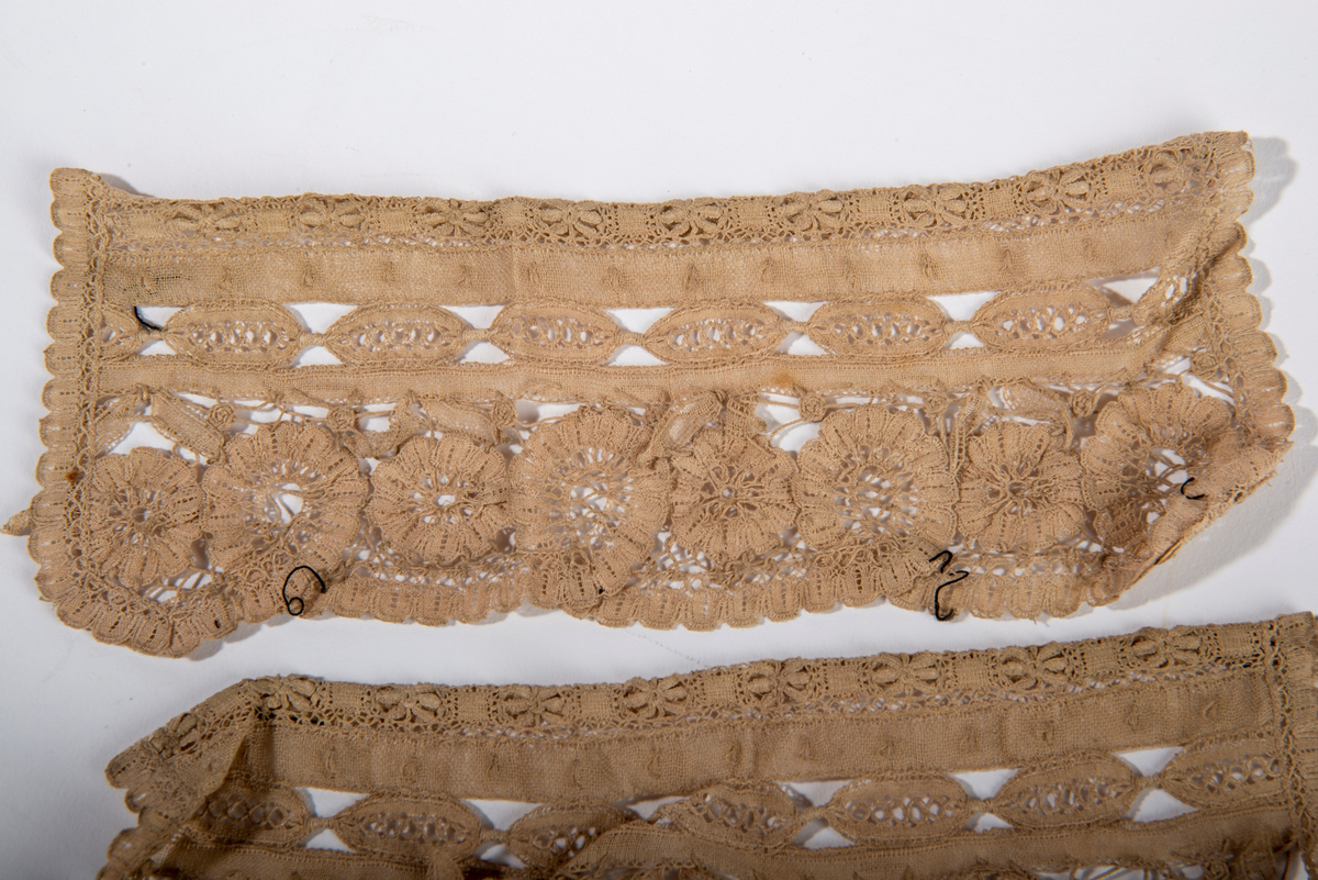 Blondekrage og tilhørende mansjetter. Beige i fargen. Border og blomstermotiv.