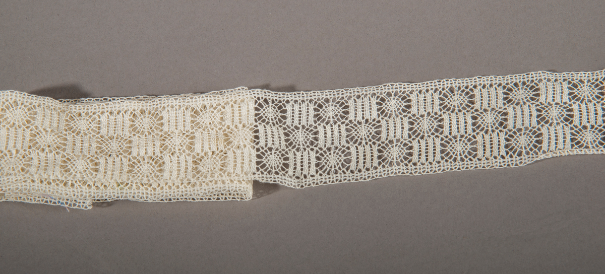 Blonderemse. Hvit. Rette kanter på hver side. Motivet er satt sammen av sirkler og kvadrater(staver), forskjøvet i forhold til hverandre slik at det danner tre border.