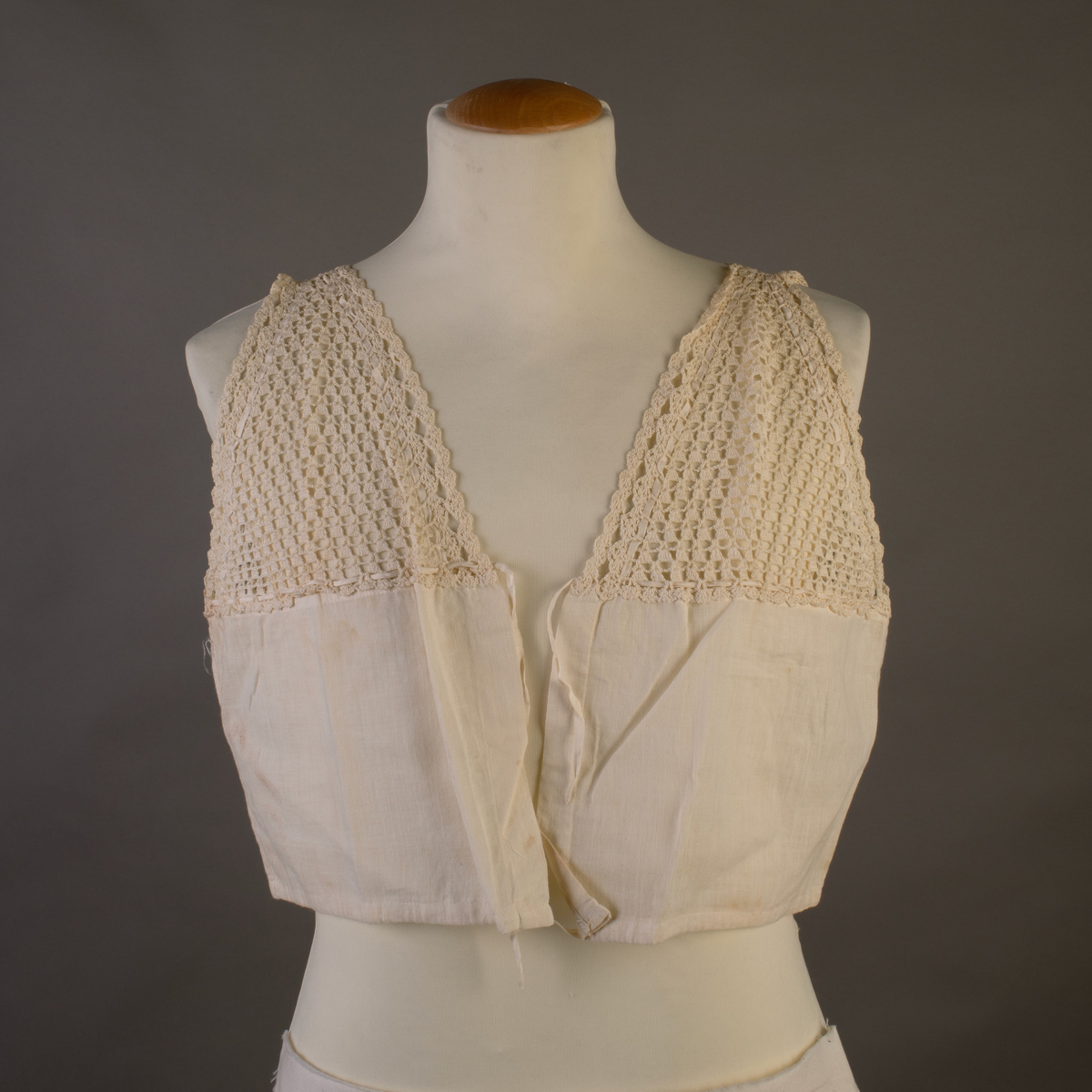 Liv i tynt bomullsstoff med heklede bærestykker. Knytesnorer.