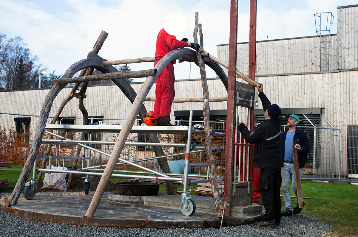 Tekst på nordsamisk lenger ned / Geahca sámegiela teavstta vuolábealde

"Flukthus/Báhtarangoahti" er et kunstverk utført av Vuogas, arkitekturkollektivet med kunstnerne og arkitektene Joar Nango og Eystein Talleraas, i nært samarbeid med innsatte og ansatte ved Ila. Verket har formen og funksjonen til en gamme, men er ikke bygget helt slik en gamme tradisjonelt blir bygget. Hovedstrukturen og de bærende elementene er tilvirket og satt sammen på tradisjonelt vis, men uten jord, torv og never slik det samiske folket gjennom tidene har benyttet seg av. Som vanlig når Vuogas engasjeres i prosjekter, har de undersøkt, funnet og brukt lokale materialer som bærer med seg historikken fra stedet. I dette tilfellet trevirke fra skogen rundt Ila, i tillegg til funnet materiale og gjenstander fra fengselet og gartneriets område. "Flukthus/Báhtarangoahti" er et arkitektonisk kunstverk, men også et oppholdssted og et sosialt rom. Det er bygget for avdelingen, med tanke for de innsatte og ansatte ved NFFA, og der intensjonen har vært at gammen og bålplassen skal bli et godt sted å være.

Joar Nango (f. 1979) er en samisk-norsk kunstner og arkitekt som bor og jobber i Tromsø. Han er utdannet arkitekt fra NTNU i Trondheim og grunnlegger av arkitekturkollektivet Vuogas sammen med Eystein Talleraas (f. 1980). Talleraas bor og jobber i Oslo, og er utdannet arkitekt fra NTNU i Trondheim.

"Báhtarangoahti/Flukthus" lea dáiddadagus, man Vuogas, dáiddára ja arkiteavtta guoktá Joar Nango ja Eystein Talleraas arkitektuvrakollektiiva lea ráhkadan, lagas ovttasbarggus Ila giddagasa fá¿ggaiguin ja virggehasaiguin.  Dáiddadahkosis lea goadi hápmi ja doaibma, muhto dat ii leat huksejuvvon jur dego goahti árbevirolaccat huksejuvvo. Riggi ja válddahagat leat ávdnejuvvon ja cohkkejuvvon árbevirolaš vuogi mielde, muhto goadis eai leat lavnnjit, darffit ja beassit, maid sápmelaccat áiggiid cada leat geavahan godiineaset. Nugo dábálaccat go Vuogas bálkáhuvvo prošeavttaide, de lea arkiteaktakollektiiva guorahallan, gávdnan ja geavahan báikkálaš ávdnasiid, main lea lagasbirrasa historihkka. Dán oktavuodas lea ávnnasmuorat vižžojuvvon vuovddis Ila birra, ja lassin leat gávdnon ávdnasat ja biergasat giddagasas ja gilvvagárdedoalu guovllus. "Báhtarangoahti/Flukthus" lea arkitektuvrralaš dáiddadagus, muhto maiddái orostallansadji ja servvoštallanlatnja. Dat lea huksejuvvon ossodaga várás, NFFA [našuvnnalaš nannejuvvon oktasašossodaga] fá¿ggaid ja virggehasaid gorrái, ja man áigumuš  lea leamaš ahte goahti ja árran galget šaddat sadjin gos lea vuogas leahkit.

Joar Nango (r. 1979) lea Norgga beali sámi dáiddár ja arkiteakta, gii ássá ja bargá Romssas. Son lea oahppan arkiteaktan NTNU:s [Norgga teknihkalaš-luonddudiedalaš universiteahtas] Tråantes/Troanddimis, ja lea vuoddudan Vuogas arkitektuvrakollektiivva ovttas Eystein Talleraas:in (r. 1980). Talleraas ássá ja bargá Osloves, ja lea oahppan arkiteaktan NTNU:s Tråantes/Troanddimis.