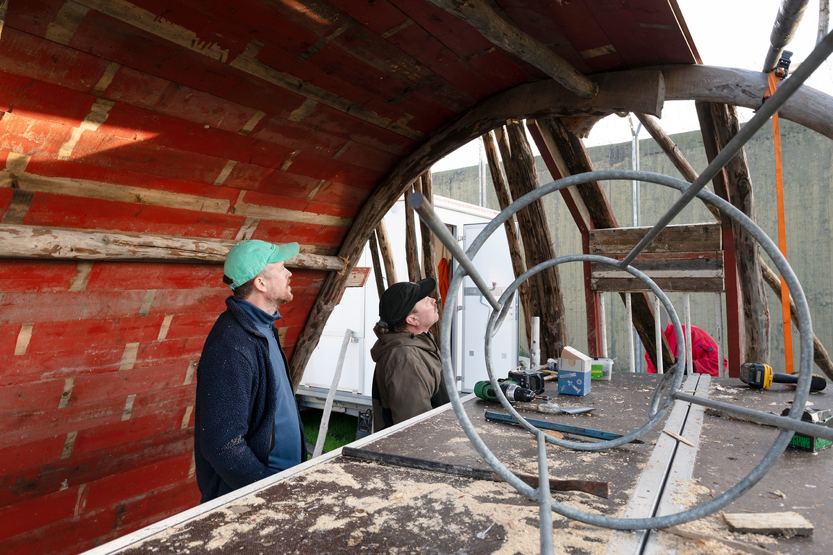 Tekst på nordsamisk lenger ned / Geahca sámegiela teavstta vuolábealde

"Flukthus/Báhtarangoahti" er et kunstverk utført av Vuogas, arkitekturkollektivet med kunstnerne og arkitektene Joar Nango og Eystein Talleraas, i nært samarbeid med innsatte og ansatte ved Ila. Verket har formen og funksjonen til en gamme, men er ikke bygget helt slik en gamme tradisjonelt blir bygget. Hovedstrukturen og de bærende elementene er tilvirket og satt sammen på tradisjonelt vis, men uten jord, torv og never slik det samiske folket gjennom tidene har benyttet seg av. Som vanlig når Vuogas engasjeres i prosjekter, har de undersøkt, funnet og brukt lokale materialer som bærer med seg historikken fra stedet. I dette tilfellet trevirke fra skogen rundt Ila, i tillegg til funnet materiale og gjenstander fra fengselet og gartneriets område. "Flukthus/Báhtarangoahti" er et arkitektonisk kunstverk, men også et oppholdssted og et sosialt rom. Det er bygget for avdelingen, med tanke for de innsatte og ansatte ved NFFA, og der intensjonen har vært at gammen og bålplassen skal bli et godt sted å være.

Joar Nango (f. 1979) er en samisk-norsk kunstner og arkitekt som bor og jobber i Tromsø. Han er utdannet arkitekt fra NTNU i Trondheim og grunnlegger av arkitekturkollektivet Vuogas sammen med Eystein Talleraas (f. 1980). Talleraas bor og jobber i Oslo, og er utdannet arkitekt fra NTNU i Trondheim.

"Báhtarangoahti/Flukthus" lea dáiddadagus, man Vuogas, dáiddára ja arkiteavtta guoktá Joar Nango ja Eystein Talleraas arkitektuvrakollektiiva lea ráhkadan, lagas ovttasbarggus Ila giddagasa fá¿ggaiguin ja virggehasaiguin.  Dáiddadahkosis lea goadi hápmi ja doaibma, muhto dat ii leat huksejuvvon jur dego goahti árbevirolaccat huksejuvvo. Riggi ja válddahagat leat ávdnejuvvon ja cohkkejuvvon árbevirolaš vuogi mielde, muhto goadis eai leat lavnnjit, darffit ja beassit, maid sápmelaccat áiggiid cada leat geavahan godiineaset. Nugo dábálaccat go Vuogas bálkáhuvvo prošeavttaide, de lea arkiteaktakollektiiva guorahallan, gávdnan ja geavahan báikkálaš ávdnasiid, main lea lagasbirrasa historihkka. Dán oktavuodas lea ávnnasmuorat vižžojuvvon vuovddis Ila birra, ja lassin leat gávdnon ávdnasat ja biergasat giddagasas ja gilvvagárdedoalu guovllus. "Báhtarangoahti/Flukthus" lea arkitektuvrralaš dáiddadagus, muhto maiddái orostallansadji ja servvoštallanlatnja. Dat lea huksejuvvon ossodaga várás, NFFA [našuvnnalaš nannejuvvon oktasašossodaga] fá¿ggaid ja virggehasaid gorrái, ja man áigumuš  lea leamaš ahte goahti ja árran galget šaddat sadjin gos lea vuogas leahkit.

Joar Nango (r. 1979) lea Norgga beali sámi dáiddár ja arkiteakta, gii ássá ja bargá Romssas. Son lea oahppan arkiteaktan NTNU:s [Norgga teknihkalaš-luonddudiedalaš universiteahtas] Tråantes/Troanddimis, ja lea vuoddudan Vuogas arkitektuvrakollektiivva ovttas Eystein Talleraas:in (r. 1980). Talleraas ássá ja bargá Osloves, ja lea oahppan arkiteaktan NTNU:s Tråantes/Troanddimis.