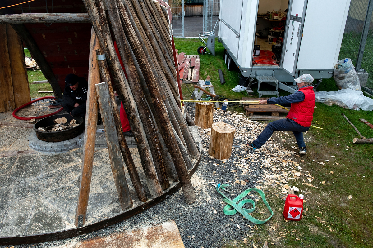 Tekst på nordsamisk lenger ned / Geahca sámegiela teavstta vuolábealde

"Flukthus/Báhtarangoahti" er et kunstverk utført av Vuogas, arkitekturkollektivet med kunstnerne og arkitektene Joar Nango og Eystein Talleraas, i nært samarbeid med innsatte og ansatte ved Ila. Verket har formen og funksjonen til en gamme, men er ikke bygget helt slik en gamme tradisjonelt blir bygget. Hovedstrukturen og de bærende elementene er tilvirket og satt sammen på tradisjonelt vis, men uten jord, torv og never slik det samiske folket gjennom tidene har benyttet seg av. Som vanlig når Vuogas engasjeres i prosjekter, har de undersøkt, funnet og brukt lokale materialer som bærer med seg historikken fra stedet. I dette tilfellet trevirke fra skogen rundt Ila, i tillegg til funnet materiale og gjenstander fra fengselet og gartneriets område. "Flukthus/Báhtarangoahti" er et arkitektonisk kunstverk, men også et oppholdssted og et sosialt rom. Det er bygget for avdelingen, med tanke for de innsatte og ansatte ved NFFA, og der intensjonen har vært at gammen og bålplassen skal bli et godt sted å være.

Joar Nango (f. 1979) er en samisk-norsk kunstner og arkitekt som bor og jobber i Tromsø. Han er utdannet arkitekt fra NTNU i Trondheim og grunnlegger av arkitekturkollektivet Vuogas sammen med Eystein Talleraas (f. 1980). Talleraas bor og jobber i Oslo, og er utdannet arkitekt fra NTNU i Trondheim.

"Báhtarangoahti/Flukthus" lea dáiddadagus, man Vuogas, dáiddára ja arkiteavtta guoktá Joar Nango ja Eystein Talleraas arkitektuvrakollektiiva lea ráhkadan, lagas ovttasbarggus Ila giddagasa fá¿ggaiguin ja virggehasaiguin.  Dáiddadahkosis lea goadi hápmi ja doaibma, muhto dat ii leat huksejuvvon jur dego goahti árbevirolaccat huksejuvvo. Riggi ja válddahagat leat ávdnejuvvon ja cohkkejuvvon árbevirolaš vuogi mielde, muhto goadis eai leat lavnnjit, darffit ja beassit, maid sápmelaccat áiggiid cada leat geavahan godiineaset. Nugo dábálaccat go Vuogas bálkáhuvvo prošeavttaide, de lea arkiteaktakollektiiva guorahallan, gávdnan ja geavahan báikkálaš ávdnasiid, main lea lagasbirrasa historihkka. Dán oktavuodas lea ávnnasmuorat vižžojuvvon vuovddis Ila birra, ja lassin leat gávdnon ávdnasat ja biergasat giddagasas ja gilvvagárdedoalu guovllus. "Báhtarangoahti/Flukthus" lea arkitektuvrralaš dáiddadagus, muhto maiddái orostallansadji ja servvoštallanlatnja. Dat lea huksejuvvon ossodaga várás, NFFA [našuvnnalaš nannejuvvon oktasašossodaga] fá¿ggaid ja virggehasaid gorrái, ja man áigumuš  lea leamaš ahte goahti ja árran galget šaddat sadjin gos lea vuogas leahkit.

Joar Nango (r. 1979) lea Norgga beali sámi dáiddár ja arkiteakta, gii ássá ja bargá Romssas. Son lea oahppan arkiteaktan NTNU:s [Norgga teknihkalaš-luonddudiedalaš universiteahtas] Tråantes/Troanddimis, ja lea vuoddudan Vuogas arkitektuvrakollektiivva ovttas Eystein Talleraas:in (r. 1980). Talleraas ássá ja bargá Osloves, ja lea oahppan arkiteaktan NTNU:s Tråantes/Troanddimis.