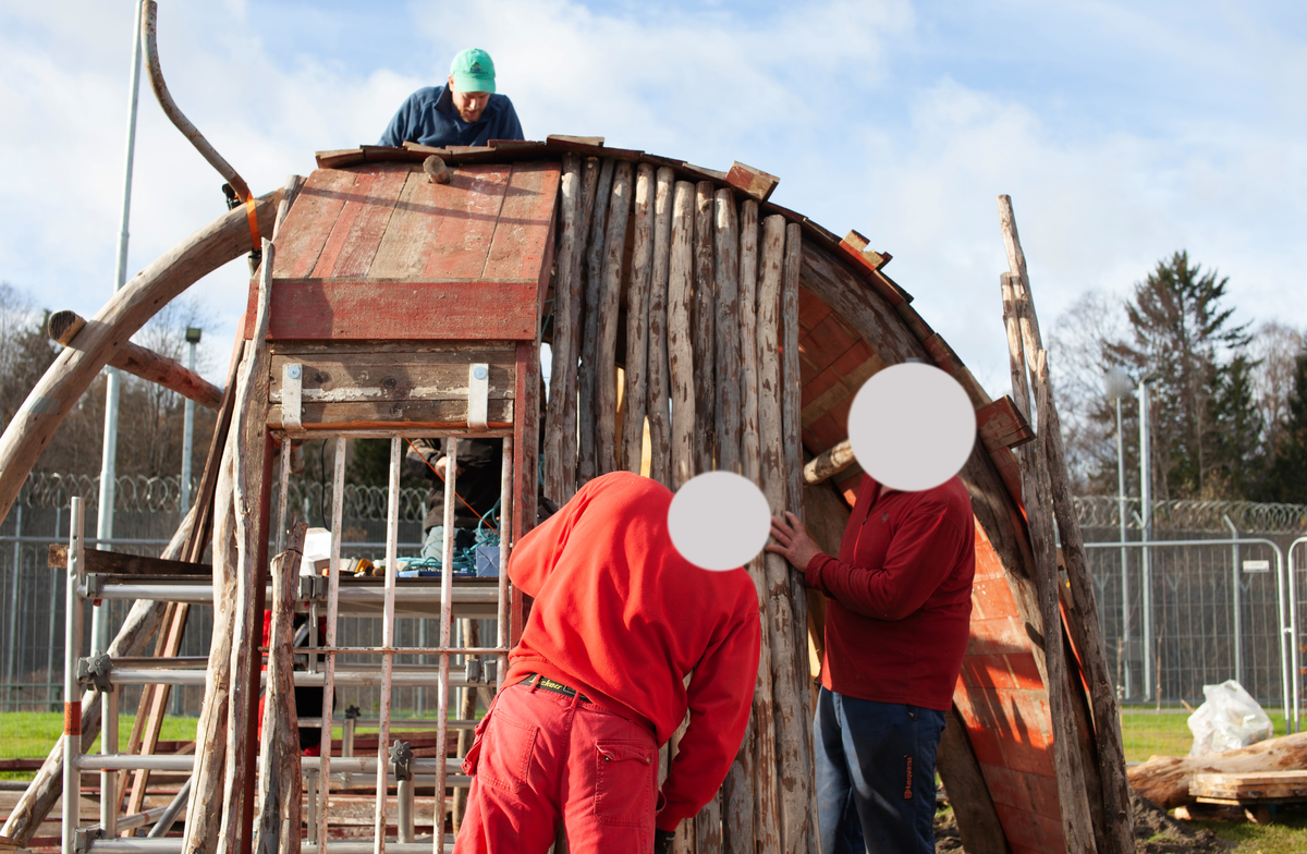 Tekst på nordsamisk lenger ned / Geahca sámegiela teavstta vuolábealde

"Flukthus/Báhtarangoahti" er et kunstverk utført av Vuogas, arkitekturkollektivet med kunstnerne og arkitektene Joar Nango og Eystein Talleraas, i nært samarbeid med innsatte og ansatte ved Ila. Verket har formen og funksjonen til en gamme, men er ikke bygget helt slik en gamme tradisjonelt blir bygget. Hovedstrukturen og de bærende elementene er tilvirket og satt sammen på tradisjonelt vis, men uten jord, torv og never slik det samiske folket gjennom tidene har benyttet seg av. Som vanlig når Vuogas engasjeres i prosjekter, har de undersøkt, funnet og brukt lokale materialer som bærer med seg historikken fra stedet. I dette tilfellet trevirke fra skogen rundt Ila, i tillegg til funnet materiale og gjenstander fra fengselet og gartneriets område. "Flukthus/Báhtarangoahti" er et arkitektonisk kunstverk, men også et oppholdssted og et sosialt rom. Det er bygget for avdelingen, med tanke for de innsatte og ansatte ved NFFA, og der intensjonen har vært at gammen og bålplassen skal bli et godt sted å være.

Joar Nango (f. 1979) er en samisk-norsk kunstner og arkitekt som bor og jobber i Tromsø. Han er utdannet arkitekt fra NTNU i Trondheim og grunnlegger av arkitekturkollektivet Vuogas sammen med Eystein Talleraas (f. 1980). Talleraas bor og jobber i Oslo, og er utdannet arkitekt fra NTNU i Trondheim.

"Báhtarangoahti/Flukthus" lea dáiddadagus, man Vuogas, dáiddára ja arkiteavtta guoktá Joar Nango ja Eystein Talleraas arkitektuvrakollektiiva lea ráhkadan, lagas ovttasbarggus Ila giddagasa fá¿ggaiguin ja virggehasaiguin.  Dáiddadahkosis lea goadi hápmi ja doaibma, muhto dat ii leat huksejuvvon jur dego goahti árbevirolaccat huksejuvvo. Riggi ja válddahagat leat ávdnejuvvon ja cohkkejuvvon árbevirolaš vuogi mielde, muhto goadis eai leat lavnnjit, darffit ja beassit, maid sápmelaccat áiggiid cada leat geavahan godiineaset. Nugo dábálaccat go Vuogas bálkáhuvvo prošeavttaide, de lea arkiteaktakollektiiva guorahallan, gávdnan ja geavahan báikkálaš ávdnasiid, main lea lagasbirrasa historihkka. Dán oktavuodas lea ávnnasmuorat vižžojuvvon vuovddis Ila birra, ja lassin leat gávdnon ávdnasat ja biergasat giddagasas ja gilvvagárdedoalu guovllus. "Báhtarangoahti/Flukthus" lea arkitektuvrralaš dáiddadagus, muhto maiddái orostallansadji ja servvoštallanlatnja. Dat lea huksejuvvon ossodaga várás, NFFA [našuvnnalaš nannejuvvon oktasašossodaga] fá¿ggaid ja virggehasaid gorrái, ja man áigumuš  lea leamaš ahte goahti ja árran galget šaddat sadjin gos lea vuogas leahkit.

Joar Nango (r. 1979) lea Norgga beali sámi dáiddár ja arkiteakta, gii ássá ja bargá Romssas. Son lea oahppan arkiteaktan NTNU:s [Norgga teknihkalaš-luonddudiedalaš universiteahtas] Tråantes/Troanddimis, ja lea vuoddudan Vuogas arkitektuvrakollektiivva ovttas Eystein Talleraas:in (r. 1980). Talleraas ássá ja bargá Osloves, ja lea oahppan arkiteaktan NTNU:s Tråantes/Troanddimis.