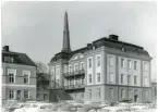 Västerås, Centrum, kv. Igor.
Del av Östra Kyrkogatan 6 till vänster och Domkyrkoesplanaden 13, från Vasagatan. 1968.