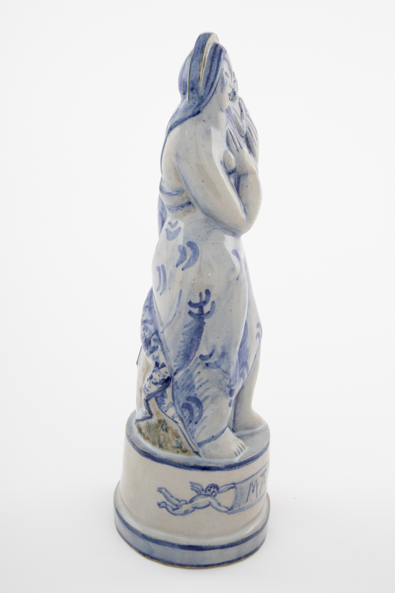 Statuett av Maria med barnet og hjort. Finkornet, gråbeige gods med blank glasur og blå og brun dekor.