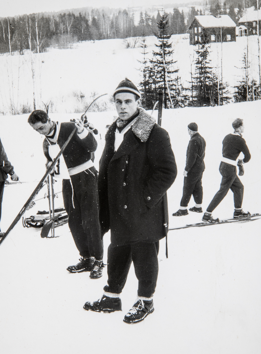 Furuberget, Vikerkollen hoppbakke i Furnes, Skibakken ved Vikerødegården. Harald Tomter er klar for skirenn med skiantrekk, strekkbukse og V-genser fra Vang Skiløberforrening. Skihopper til venstre med deltagernummer, smører skiene før rennet. Ca. 1950.
Fra et album som tilhører Harald Tomter (f.1932).