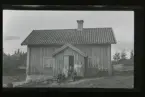 En familj framför sitt hus.