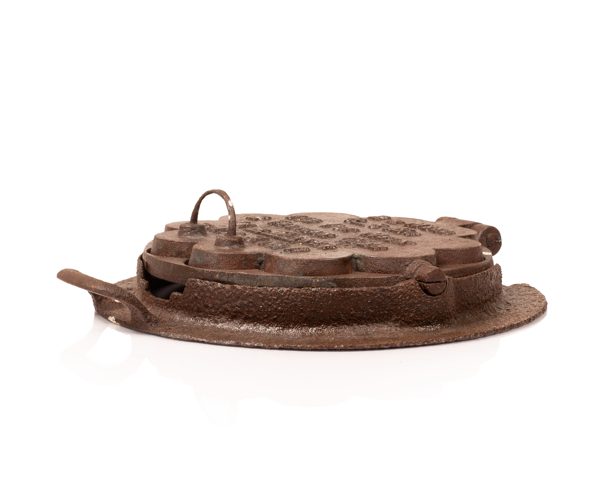 Kakejern for vafler produsert i støpejern. Jernet lager vafler med fem hjerter. Jernet er tilpasset ringkomfyren og har en ramme rundt som settes på kanten av hulle i komfyren. Jernet kan snus 180 grader rundt sin egen akse ved hjelp av to sylindere som hviler på spor i rammen.  

Jernet åpnes ved hjelp av et håndtak festet i en av endene på oversiden av lokket. På motsatt side er det et en hengsel som fester over og undersiden av jernet sammen. På lokket er det også støpt inn en oppskrift på vafler. Rammen til jernet har et håndtak i ene enden. På motsatt side er det en tydelig skade i rammen som tilsier at det har vært et identisk håndbak også her. 

Jernet viser tydelige tegn på rust grunnet oksidering. 