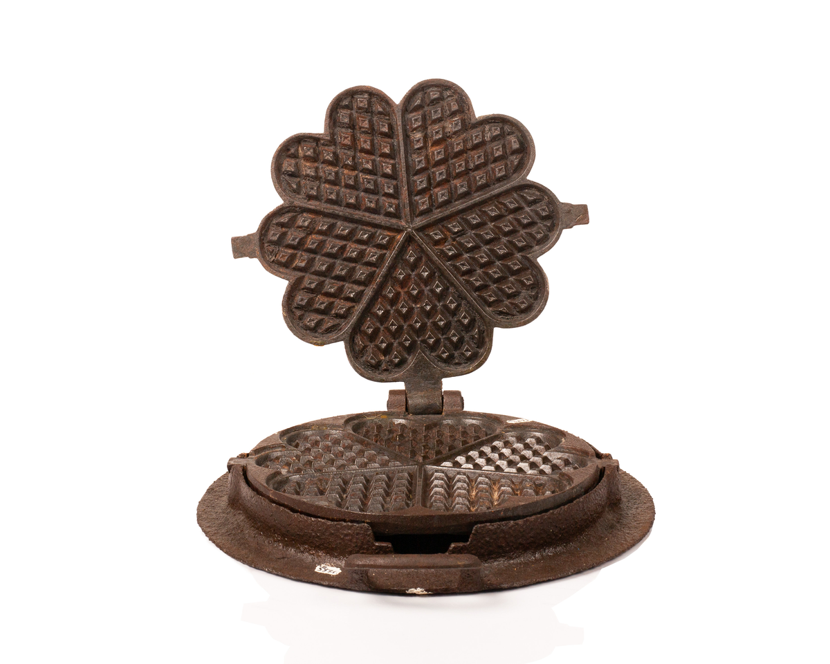 Kakejern for vafler produsert i støpejern. Jernet lager vafler med fem hjerter. Jernet er tilpasset ringkomfyren og har en ramme rundt som settes på kanten av hulle i komfyren. Jernet kan snus 180 grader rundt sin egen akse ved hjelp av to sylindere som hviler på spor i rammen.  

Jernet åpnes ved hjelp av et håndtak festet i en av endene på oversiden av lokket. På motsatt side er det et en hengsel som fester over og undersiden av jernet sammen. På lokket er det også støpt inn en oppskrift på vafler. Rammen til jernet har et håndtak i ene enden. På motsatt side er det en tydelig skade i rammen som tilsier at det har vært et identisk håndbak også her. 

Jernet viser tydelige tegn på rust grunnet oksidering. 