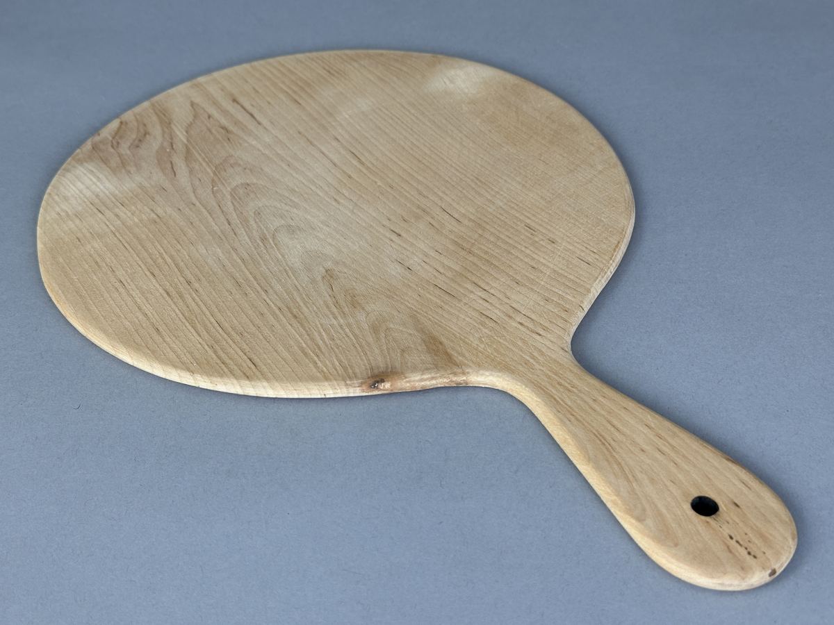 Rund brödspade/serveringsbräda med handtag av trä.
