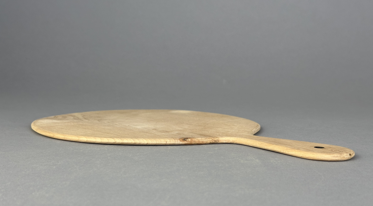 Rund brödspade/serveringsbräda med handtag av trä.