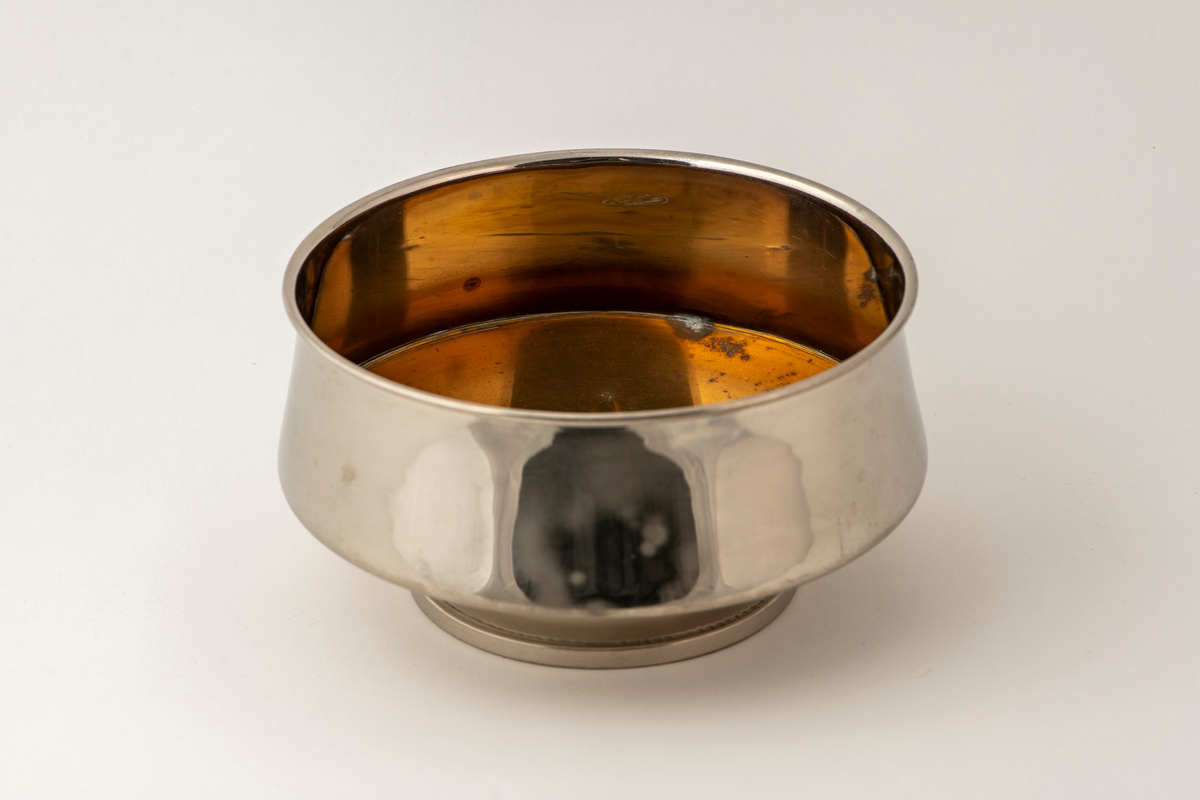 Samovar. Rund fot på fire utskrånende føtter. Stett med gjennombrutt dekor. Korpus med sider med rifler og avlange fasetter. To runde, tverr-riflede hanker av ben. Profilert overstykke med to benknotter. Ovalt fabrikkmerke med russisk tekst. Toppstykke med tre gjennombrutte ornamenter, nedsenket tungt lokk med ben-knott. Kran nederst på korpus, åpning i bunnen, og liten åpning for damp på overstykket.

Pipe. Forkrommet, skaft av messing og ben. Høy sylinderformet med utskrådd fotstykke, uten bunn, stjerthank.

Dryppskål av messing, utvendig forkrommet. Skål på stett. Midt i bunnen innvendig er det et ovalt firmamerke med russisk tekst.

Brett av forkrommet messing. Firkantet smal del, den annen halvdel bredere med rundet kontur.