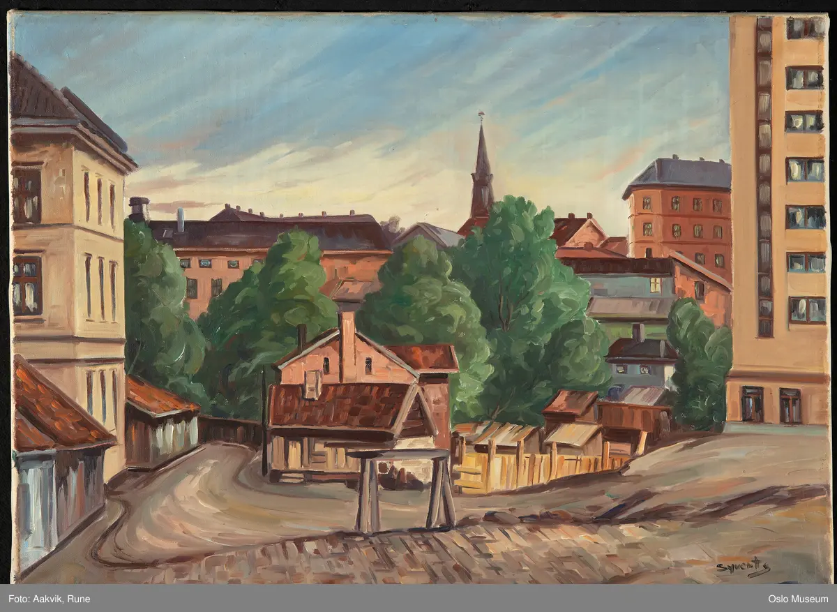 Gatemiljø med trehusbebyggelse, murgårder og vegetasjon. Slåmotgangen, Vaskegangene, Christian Krohgs gate 34, Oslo kommunes herberge for menn oppført 1939. Tårnet på Østre Frikirke.