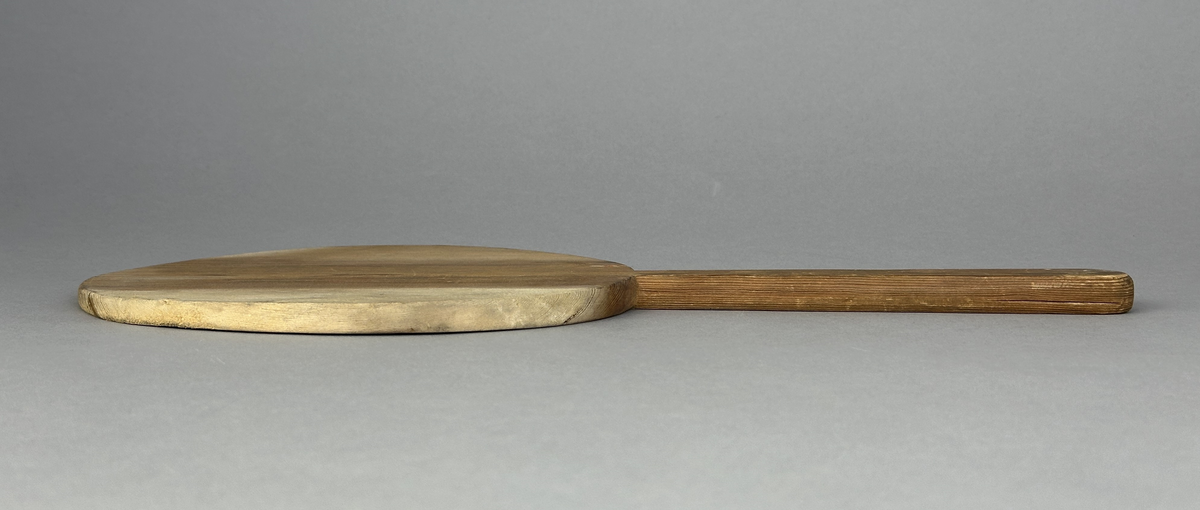 Oval brödspade eller skärbräda med skaft i trä.