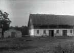 Det rådde uppenbarligen en febril byggnadsakivitet på båda Smissparterna på 1910-talet, man förnyade så gott som hela byggnadsbeståndet. Det märkliga med Artur Karlssons part var att man byggde ena vinkeln av ladugården i bulteknik, det hade man i stort sett slutat med på 1910-talet. Men moderna fönster satte man in! Stendelen innehöll fähus och buldelen lada.

T v skymtar källaren, se Bild 1059.