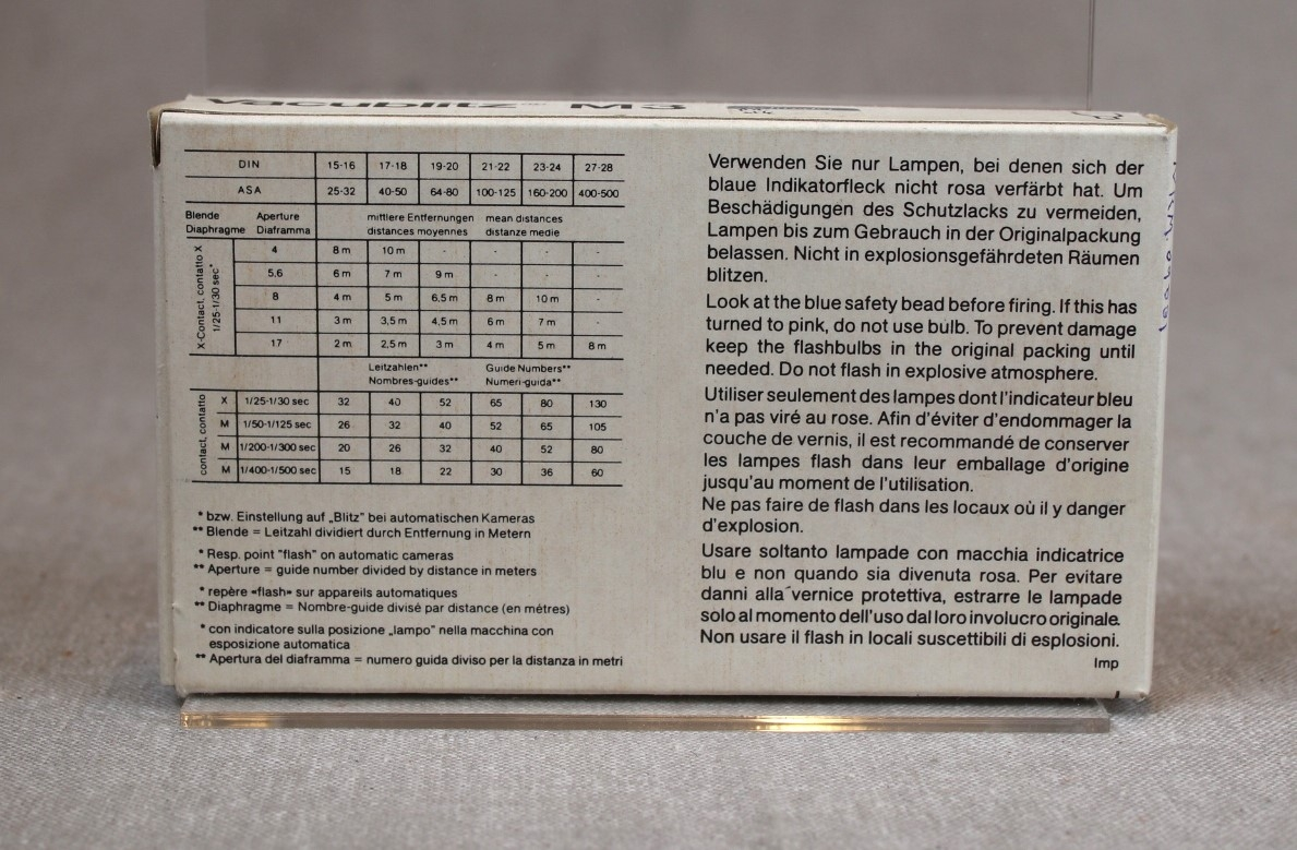 Pappeske med Osram blitzpærer, type Vacublitz M3. Pakken er åpnet og inneholder 5 pærer. Baksiden av pakken viser en rekke sjemaer med bruksområder og advarseler.