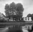 Linköpingsmiljö vars tomt idag begränsas av Vattengatan och Strandgatan. Något bortom bildens villa lät staden i en framtid uppföra Tekniska verkens anläggning utmed Hamngatan. Foto 1937. Vid tiden utgjorde Strandgatans västliga sträckning del av Nygatan, vilket förklarar platsens historiska adress Nygatan 2.