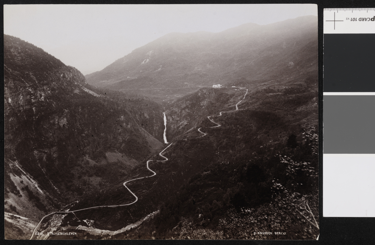 Fjellandskap i fugleperspektiv med en vei som bølger og snor seg gjennom terrenget.