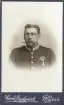 En man i full uniform med orden.
Ateljéfoto.
Musikfanjunkaren C.G. Carlsson. Född 1855.
Undersergeant, svärdsman. Avsked med pension 1905.