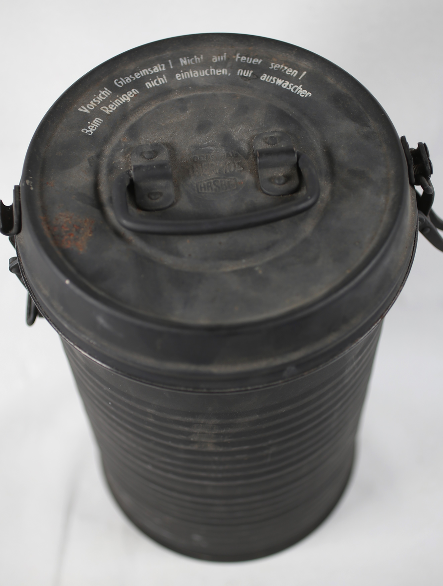 Metallbeholder med mettallokk som kan låses på to sider. Innvendig glass