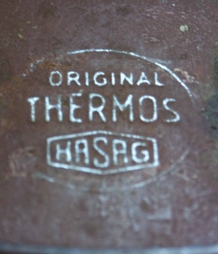 Metallbeholder med mettallokk som kan låses på to sider. Innvendig glass