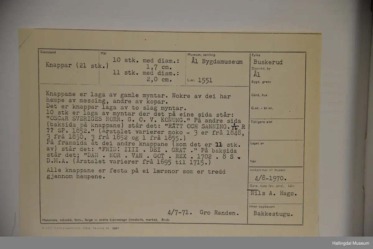 21 knappar laga av gamle myntar. Nokre av dei har hempe av messing, andre av kopar. Det er knappar laga av to slags myntar. Alle knappane er festa på ei lærsnor som er tredd gjennom hempene.