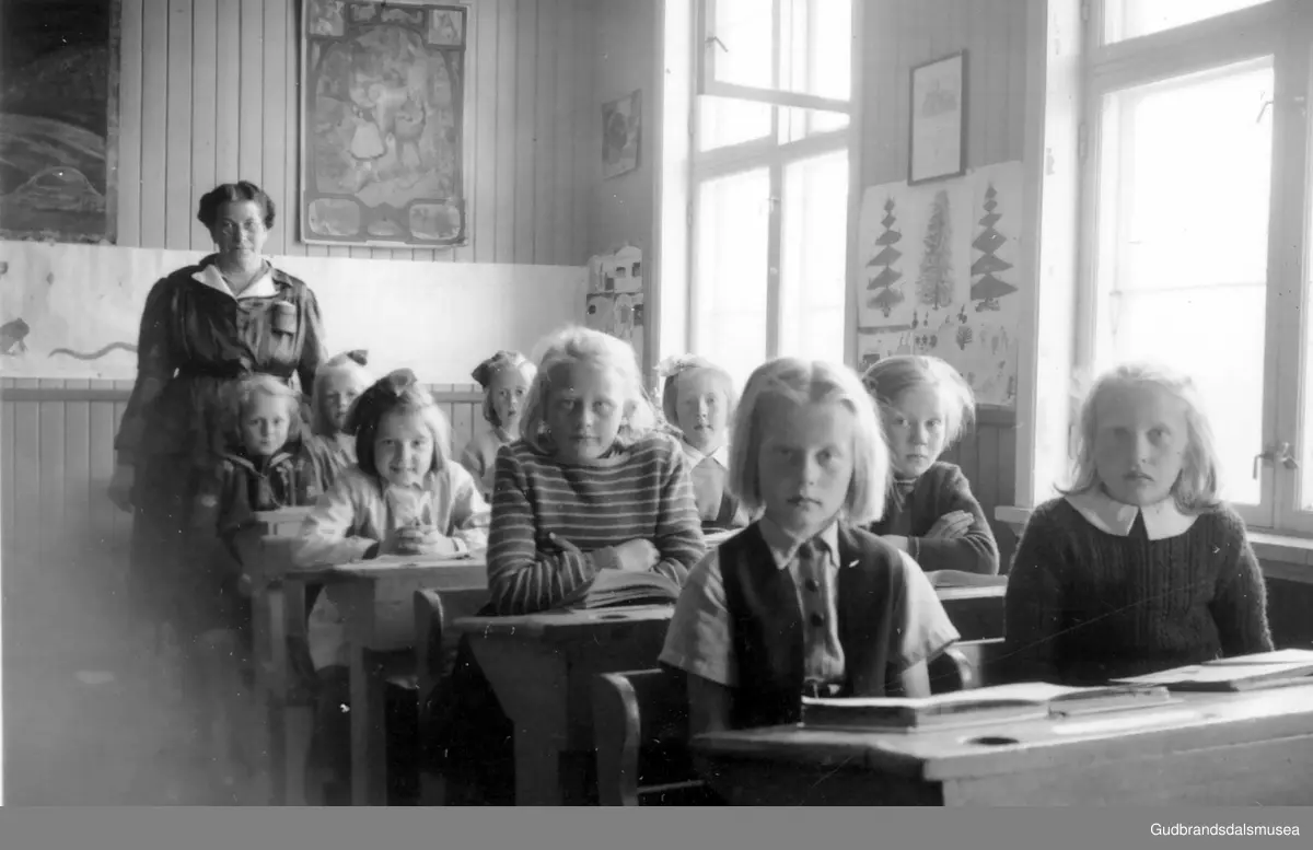 Skoleklasse på Steinbakken, Dombås. Lærerinne er Jenny Lie. Første pult Helga Berg-Domås, ??. Andre pult: Grethe Eide, Synnøve Blestrud. Tredje pult: Else-Marie Løkken, ??. Fjerde pult: Åse Grethe Botten (Myren), Kari Snipen