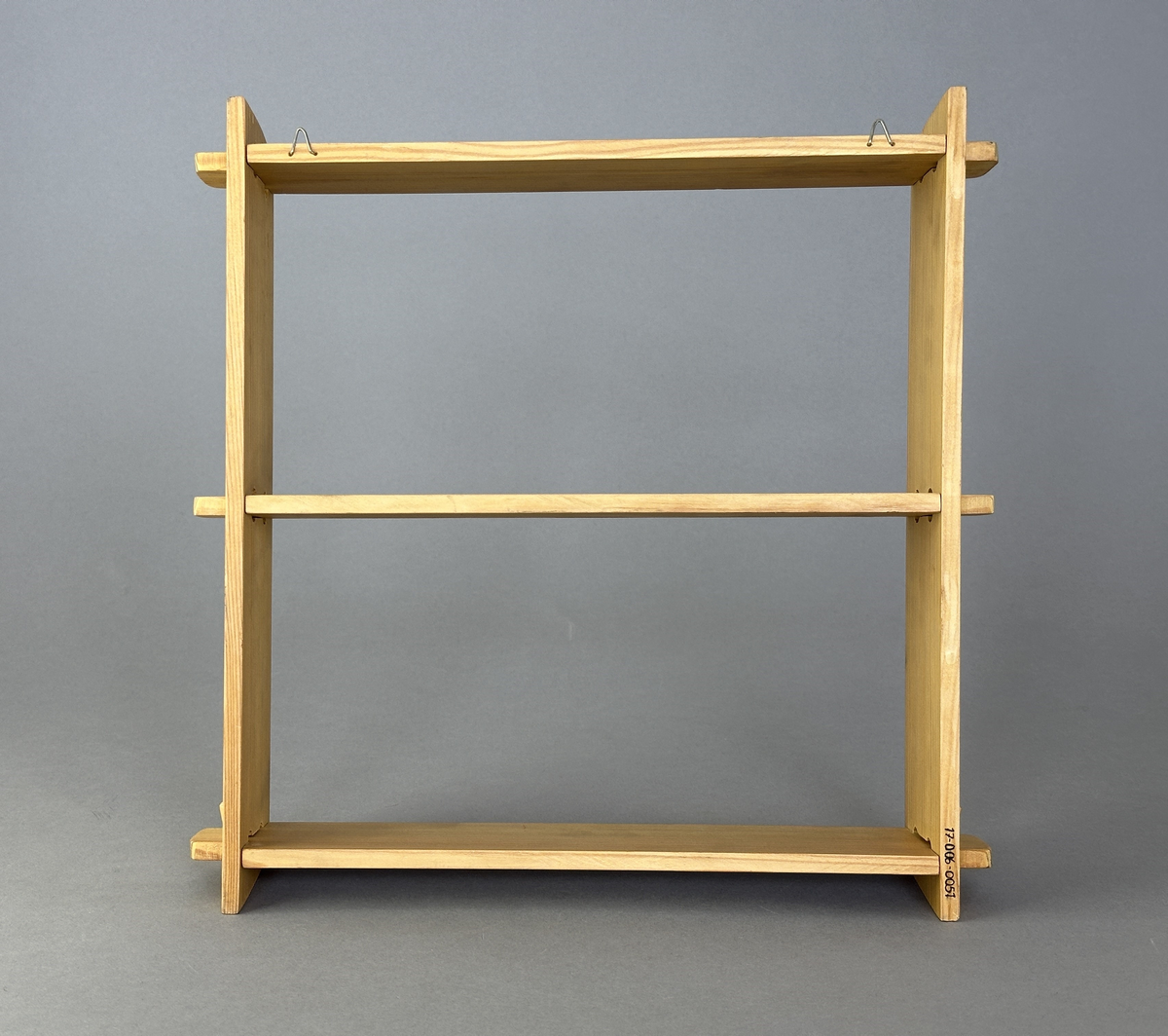 Hylla av trä med tre hyllplan för upphängning på vägg.