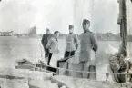 Två oidentifierade officerare i uniform m/1910, en äldre man och en pojke i motorbåt. Kalmar regemente.