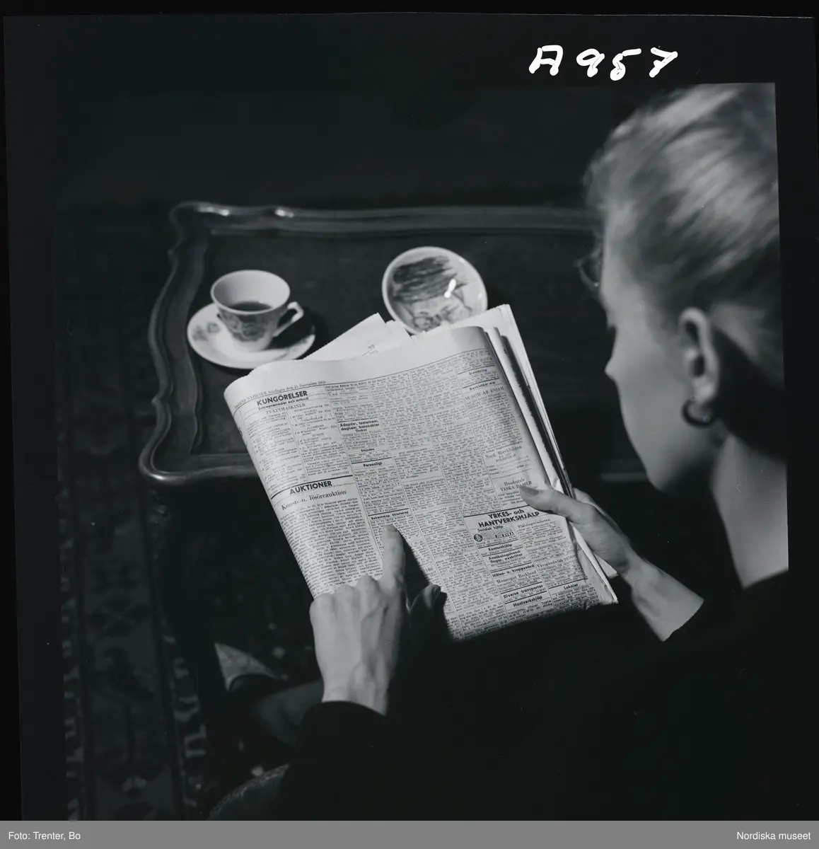  
En kvinna har slagit upp sidan för äktenskapsannonser i en dagstidning. 

(Illustrationsbild för artikel om äktenskapsannionser i tidningen Trivsel  1958)