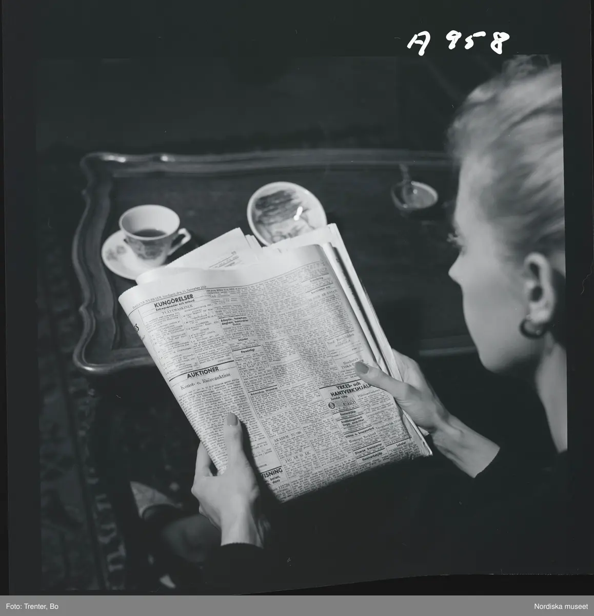  
En kvinna har slagit upp sidan för äktenskapsannonser i en dagstidning. 

(Illustrationsbild för artikel om äktenskapsannionser i tidningen Trivsel  1958)