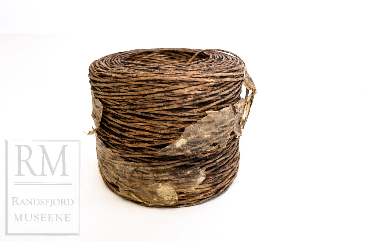 En bunt med vokset papirtau/ snor. Brukt i stedet for vanlig selvbindergarn under 2. verdenskrig. Papirtauet var dårlig egnet til den bruken det var ment for. 