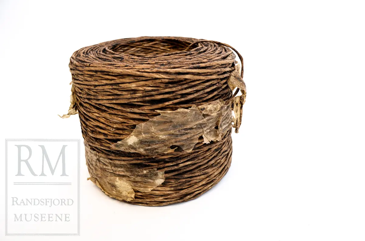 En bunt med vokset papirtau/ snor. Brukt i stedet for vanlig selvbindergarn under 2. verdenskrig. Papirtauet var dårlig egnet til den bruken det var ment for. 