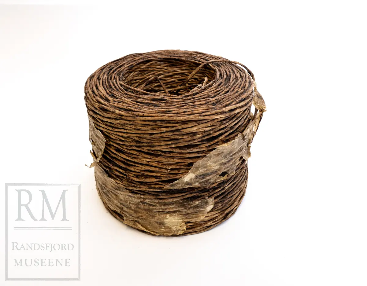 En bunt med vokset papirtau/ snor. Brukt i stedet for vanlig selvbindergarn under 2. verdenskrig. Papirtauet var dårlig egnet til den bruken det var ment for. 