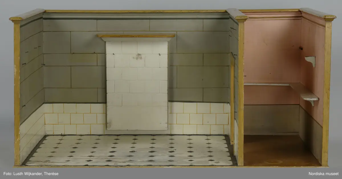 Inventering Sesam 1996-1999:
L 88  H 43,5  Dj 44   cm
Dockskåp, köksdockskåp, av trä, skafferi och kök, utvändigt träådrat. Väggarna i köket kvadermålade och golvet svart och vitrutigt. Skafferiets väggar rosa, väggfasta hyllor, dörrposten ekimiterad.
Lös inredning se inv. 192.992-193.058
Birgitta Martinius 1996