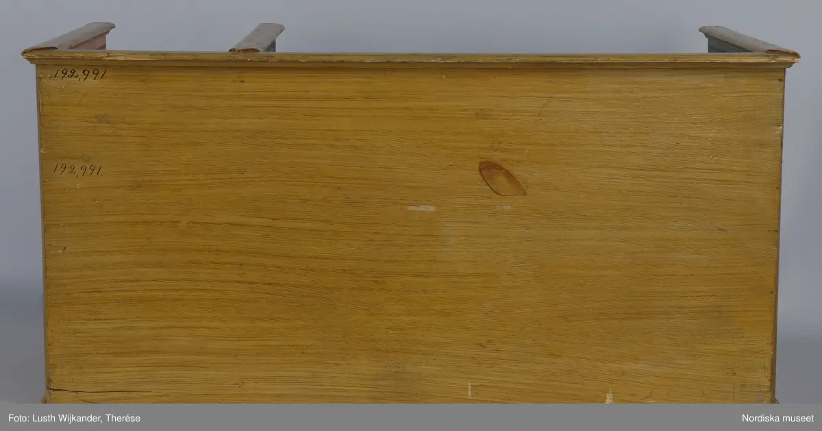 Inventering Sesam 1996-1999:
L 88  H 43,5  Dj 44   cm
Dockskåp, köksdockskåp, av trä, skafferi och kök, utvändigt träådrat. Väggarna i köket kvadermålade och golvet svart och vitrutigt. Skafferiets väggar rosa, väggfasta hyllor, dörrposten ekimiterad.
Lös inredning se inv. 192.992-193.058
Birgitta Martinius 1996