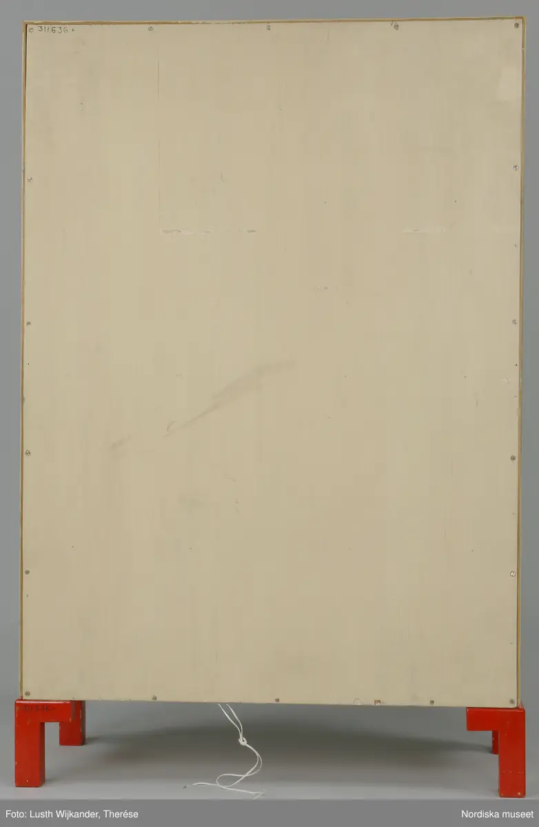 Inventering Sesam 1996-1999:
B 77,5, Djup 36,0, H 119,0 cm
Dockskåp av furu med mellanväggar av plywood, målat i gräddgult, fasaden "putsad" med färg blandad med sågspån. Dockskåpet har dubbeldörrar med lås och en fasad på gångjärn med en dörr och 10 fönster, inspirerad av det första kollektivhuset i funkisstil på John Erikssons gata. Dockskåpet är befolkat av fam. Björnerholm. Gunvor Svartz-Malmberg f. 1925-6 var ca 10 år när hon fick skåpet. 
LS 85
Helena Carlsson
