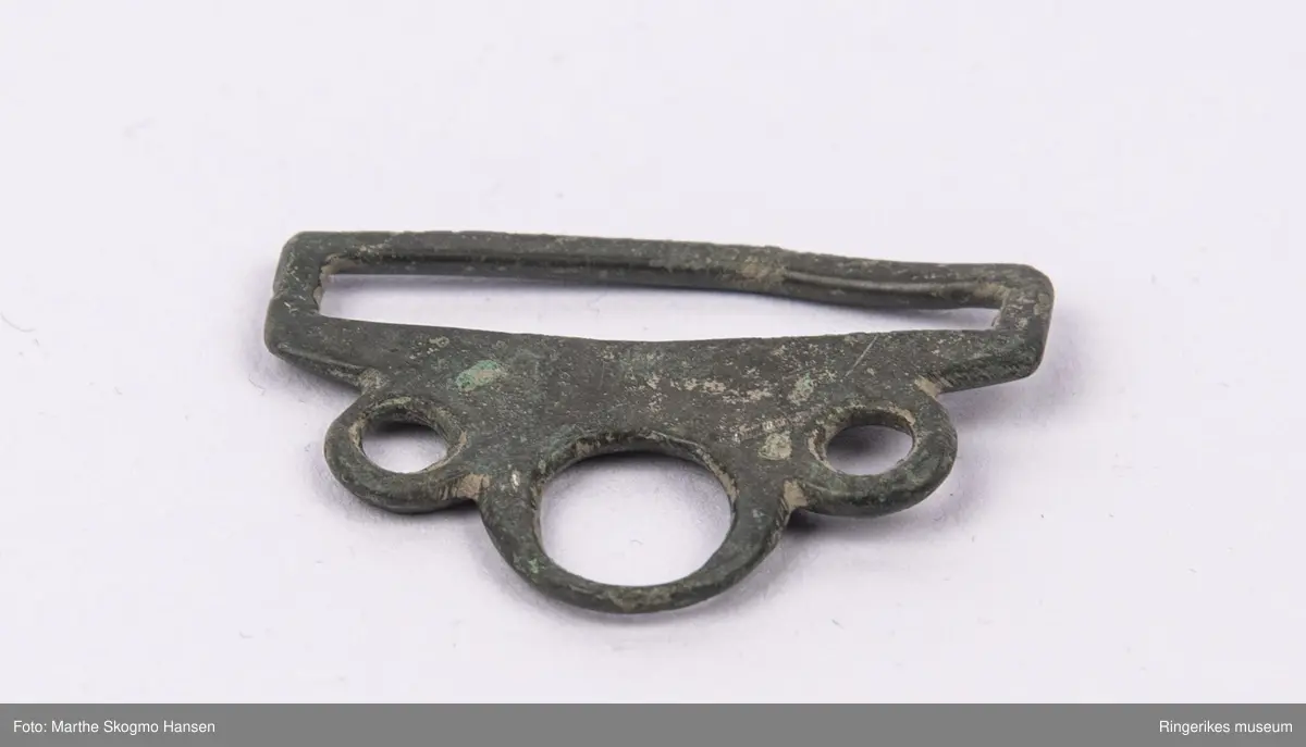 Spenne, antakelig beltespenne, av metall med sirkeldekor.