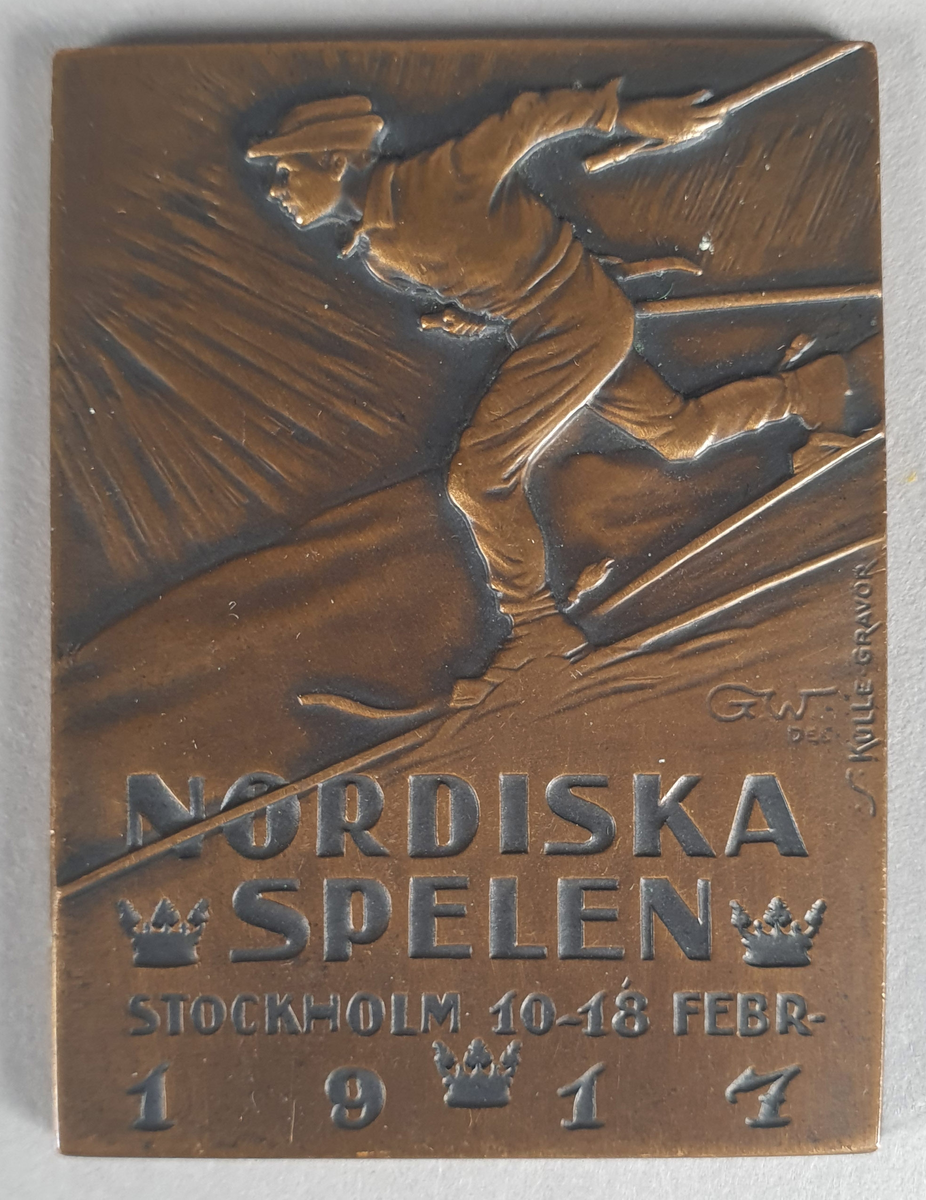 Firkantet medalje, rekangulær form, av bronse, med skiløper i relieff.