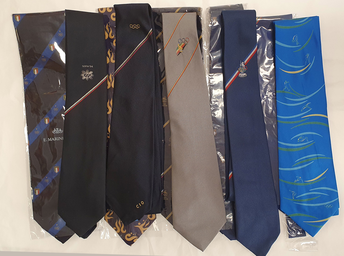 Samling av slips med logoer fra Norges Idrettsforbund, Lillehammer '94, diverse OL, rødt skinnslips fra søkerperioden for Lillehammer OL, ulike søkerkomiteer til OL, ulike nasjonale olympiske komiteer, VM-arrangører, sportsarrangement o.l. Totalt 100 stk.