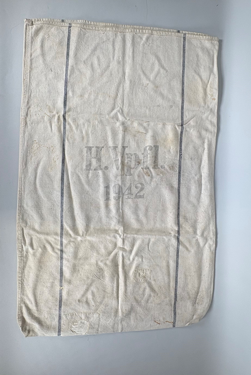 Lys sekk med 2 mørkeblå striper i lengderetningen. Tekst: "H.Vpfl - 1942".
Tysk riksørn over en krans med hakekors er trykket på en side av sekken. Sekken er reparert.